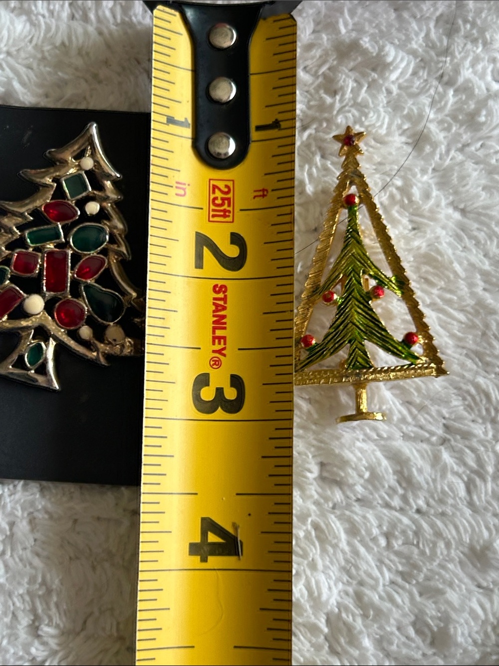 Two Christmas tree brooches.